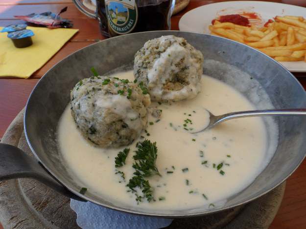 Spinatknödel mit Käsesoße ist eine Spezialität der Alpenküche. Spinatknödel